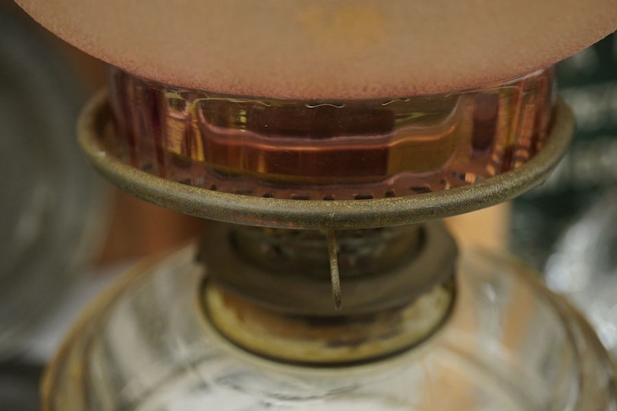 A late 19th century brass and glass oil lamp with later shade, 56cm high. Condition - chip to base and shade cut down